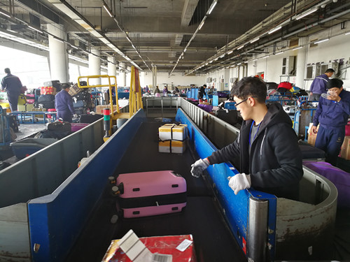 1486626606039054537.jpg 2參與幫忙行李分揀人員耐心地在轉(zhuǎn)盤處進行分撥行李。_副本.jpg